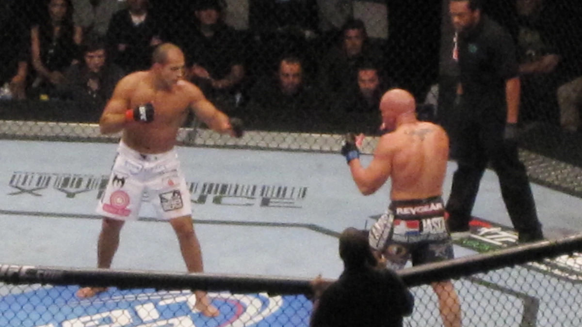 MMA cage action — striking and grappling distance.
